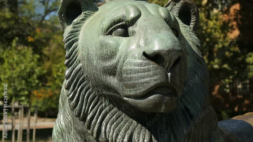 Big statue of lying lion on street in city, depiction of animals, symbolism Big statue of lying lion on street in city, depiction of animals, symbolism