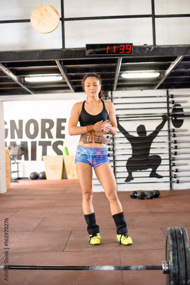 Girl standing infront of weights Girl standing infront of weights