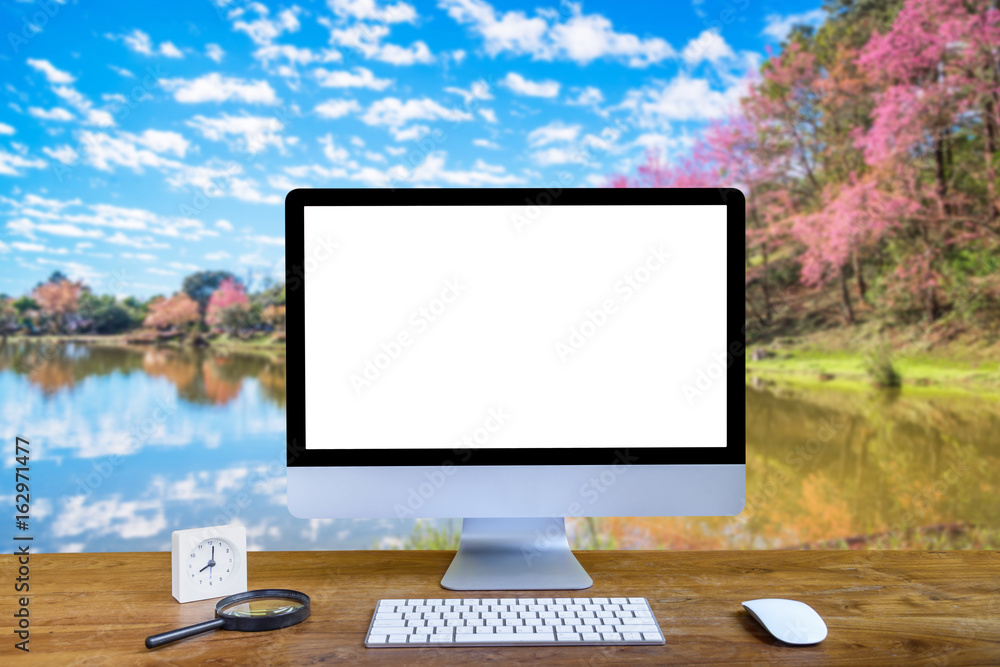 Computer with blank screen, keyboard and mouse with magnifying glass and alarm clock on table isolated cherry blossom garden background. Computer with blank screen, keyboard and mouse with magnifying glass and alarm clock on table isolated cherry blossom garden background.