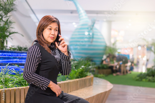 Attractive asian businesswoman talking on mobile phone with client