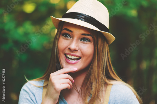 Portrait of a woman in the forest with a backpack and hat