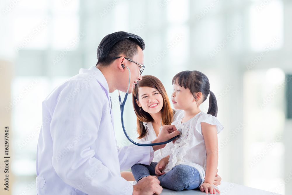 Doctor examining a girl by stethoscope at hospital Doctor examining a girl by stethoscope at hospital