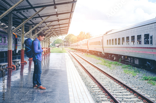Traveler man  waits train on railway platform © joyfotoliakid