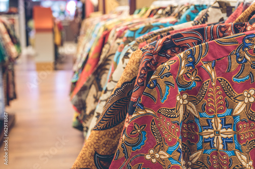Clothes hang on a shelf in a shopping mall on Bali island, Indonesia. Indonesian cotton batik.