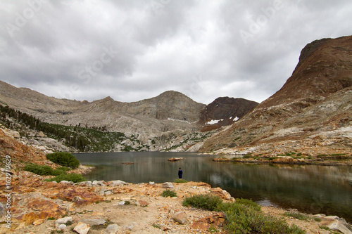 Man standing alone by lake ...