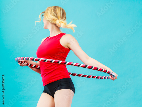 Fit woman with hula hoop doing exercise photo