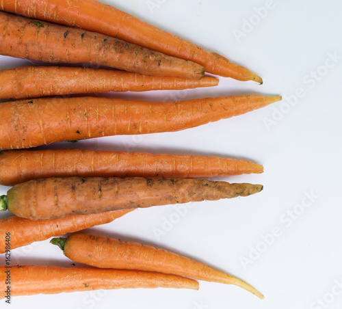 Aerial view of fresh organic carrots with white background