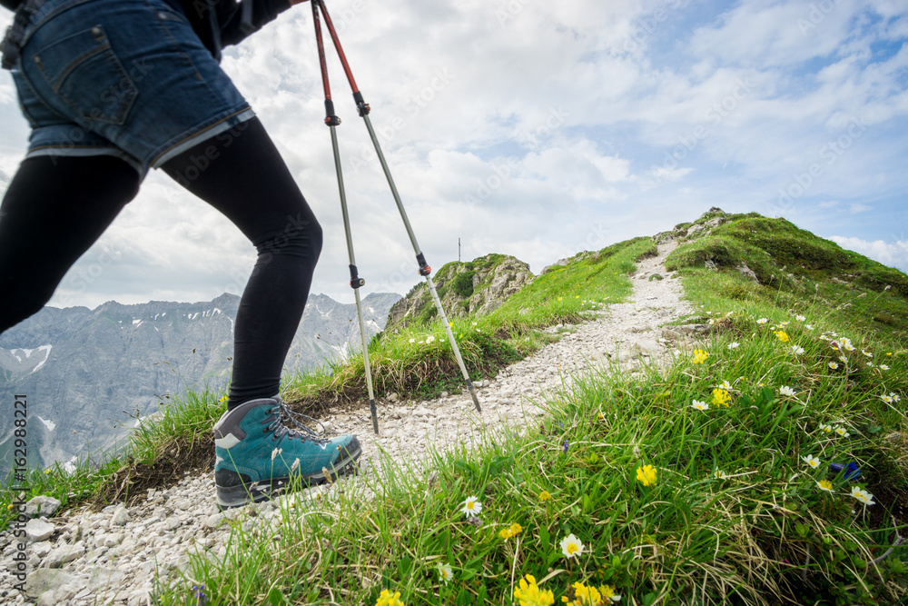 Woman running on narrow mountain trail with hiking poles. Woman running on narrow mountain trail with hiking poles.