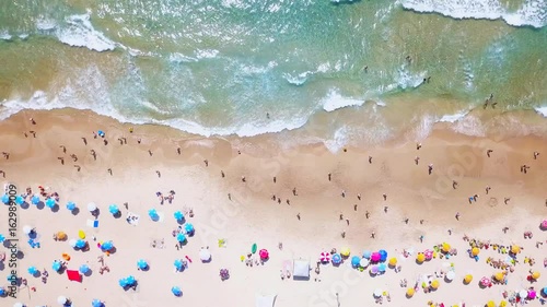 Aerial Time lapse Tropical beach with colorful umbrellas - Top down view