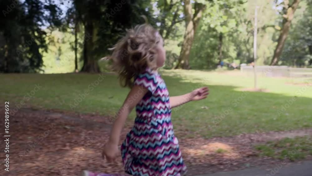 Happy Little Girl Skips Down Path In Park (Slow Motion) Happy Little Girl Skips Down Path In Park (Slow Motion)