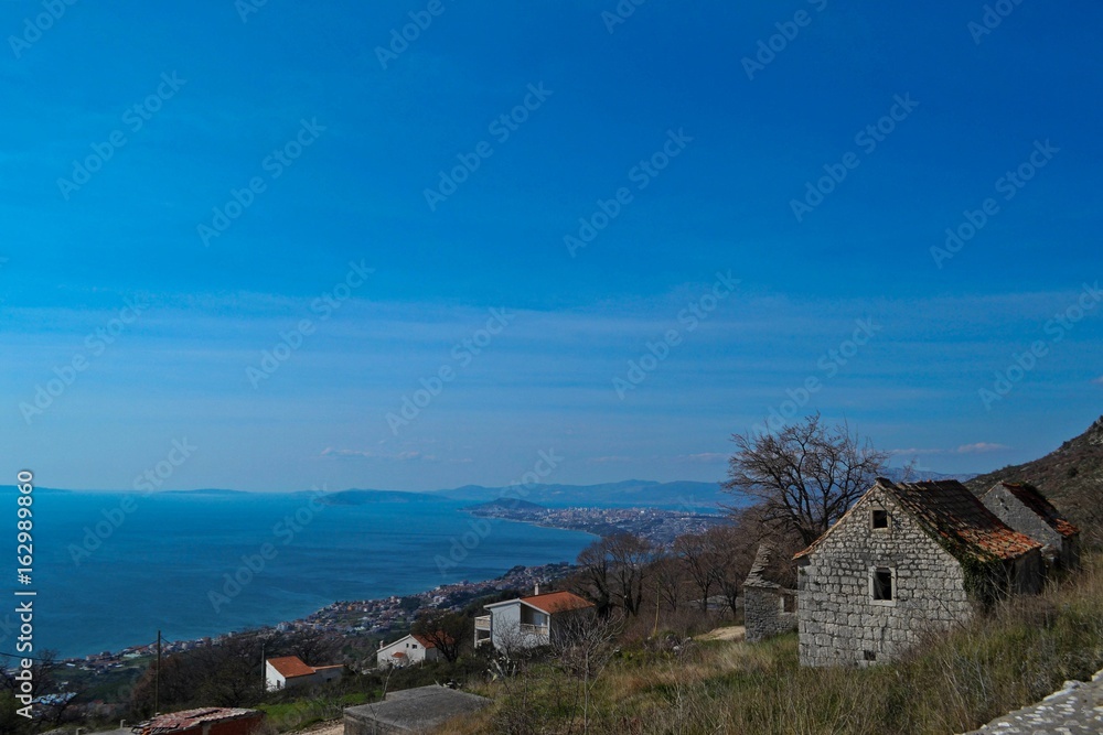 Stone village house whit the panoramic view on the blue sky and sea