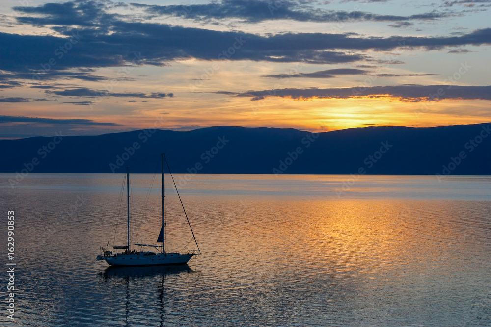 Yacht on sunset background