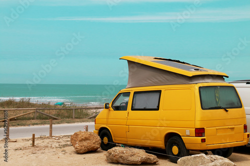 Yellow van parked on the beach