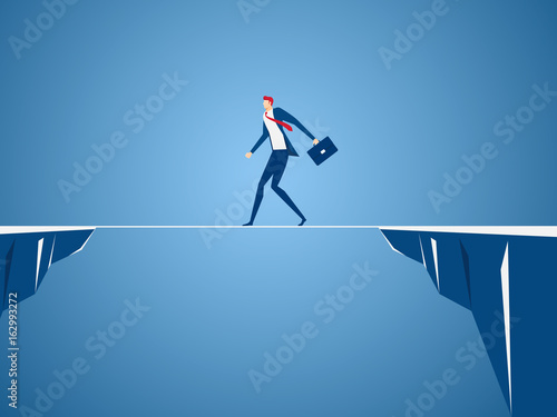 Businessman walking tightrope across the gap between hill. Walking over cliffs.Business risk and success concept.