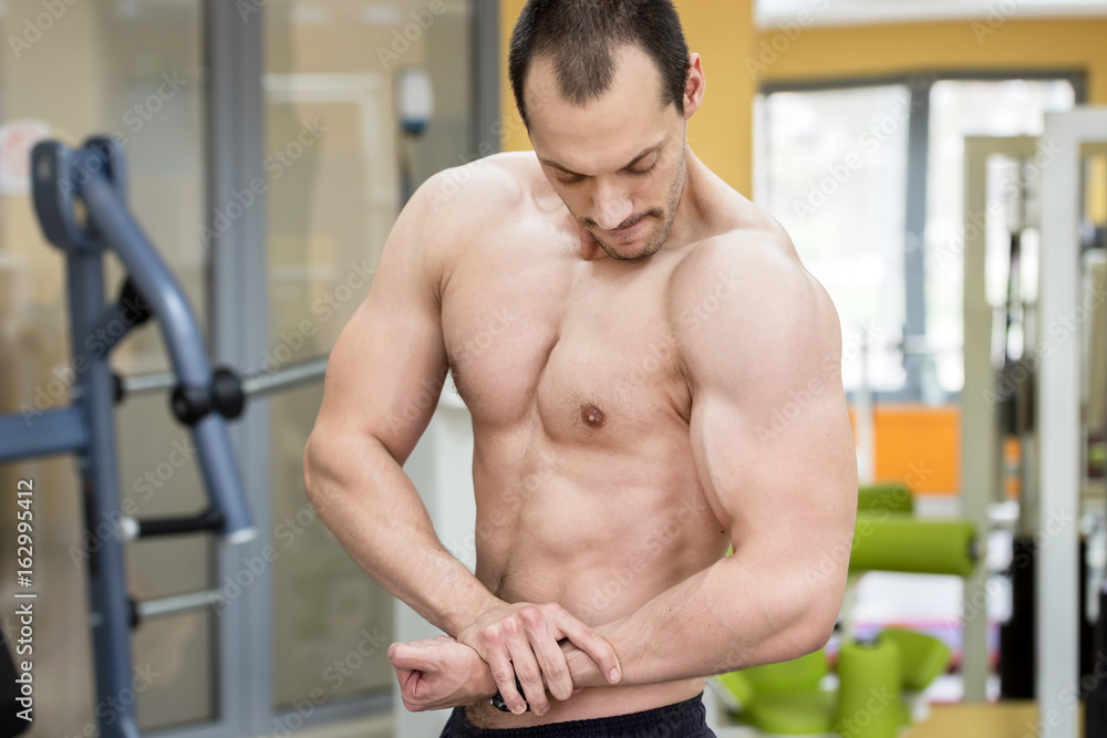 Obraz premium bodybuilder man posing in fitness club