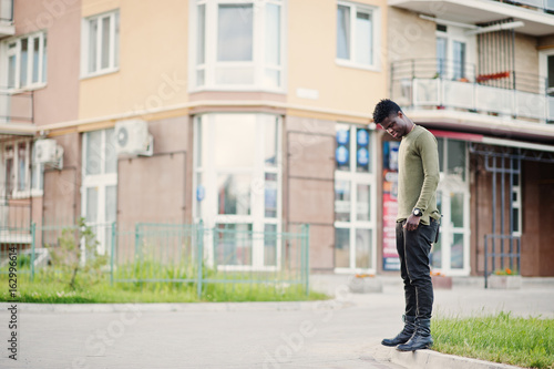 Handsome and attractive african american man posing next to the tall building on a street. © AS Photo Family