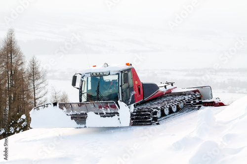 Foto Red winter ratrak parked in slope in the snow.