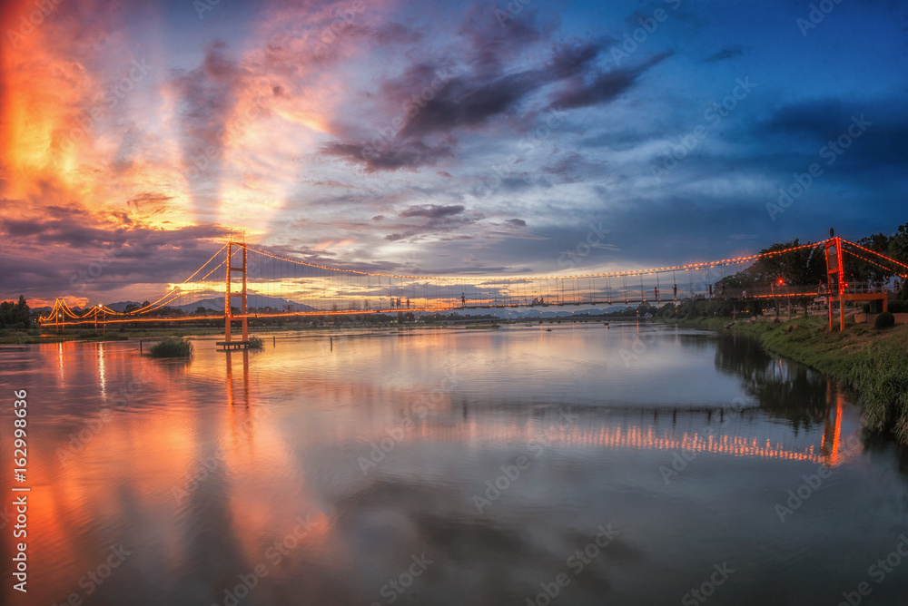 Obraz premium Landscape of sunset bridge crossing Ping river at Tak ,Thailand