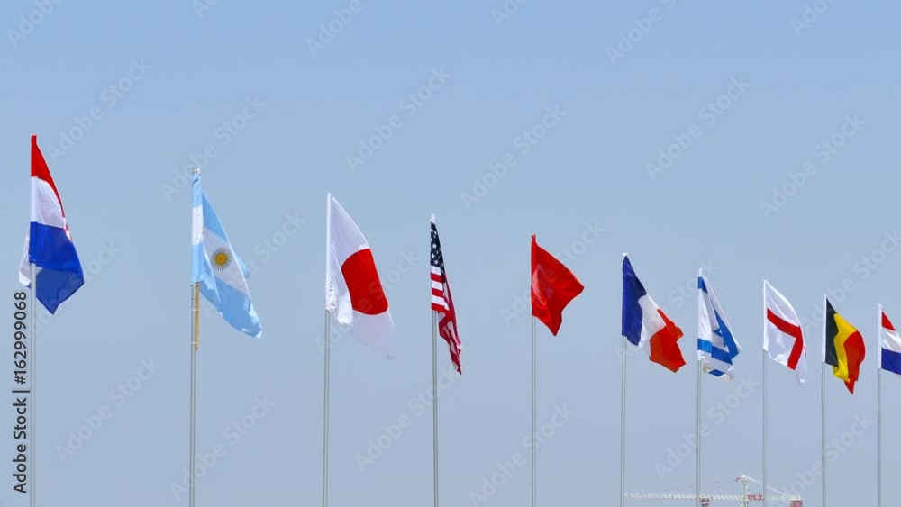 Various national flags waving in the wind on a sunny day. Various national flags waving in the wind on a sunny day.
