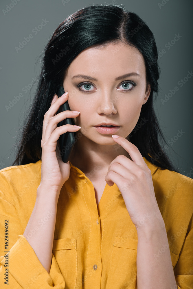 sensual beauty in yellow blouse talking on smartphone, isolated on grey sensual beauty in yellow blouse talking on smartphone, isolated on grey