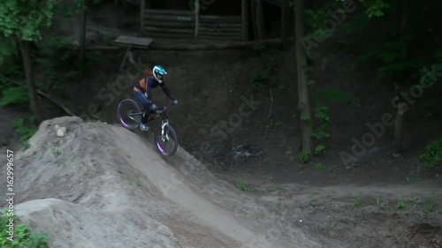 Dirt riding on bike jumping in the forest slow motion photo