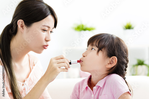 happy Mother and little girl  doing your makeup .
