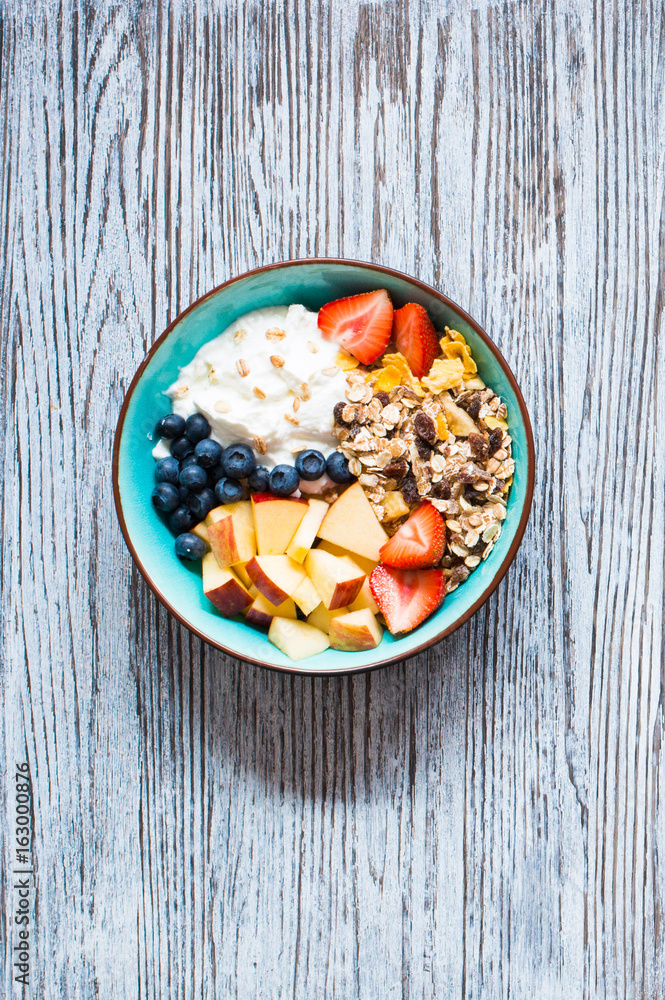 Healthy breakfast, cereal with yogurt, strawberries, blueberry, apple, banana, on rustic wooden. Top view Healthy breakfast, cereal with yogurt, strawberries, blueberry, apple, banana, on rustic wooden. Top view