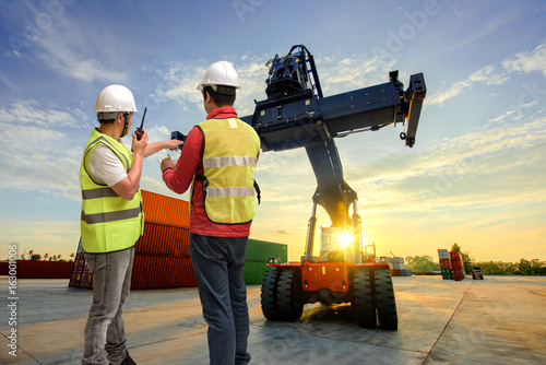 foreman working in container yars checking and report online by protable device photo