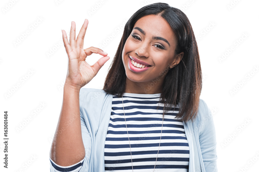 Cheerful young woman showing ok sign and smiling at camera Cheerful young woman showing ok sign and smiling at camera