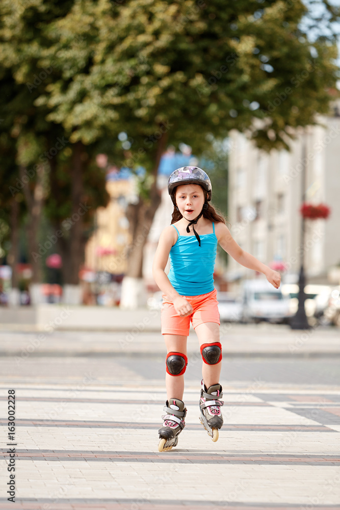 Obraz premium Cute little girl learning to roller skate outdoors on beautiful summer day