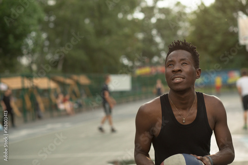 African american man plays on street basketball court. Real and authentic activity.
