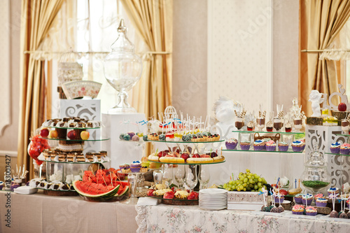 Gorgeous-looking wedding table with various beverages, delicious dishes, fruits and decorations.