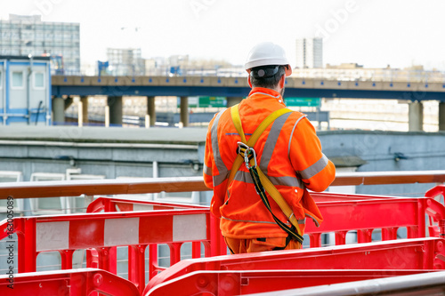 Photography Back view of a construction worker walking into a building site in Canary Wharf