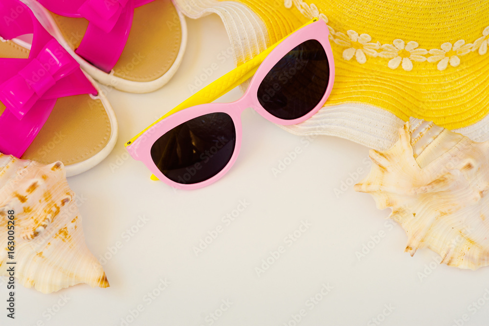 Beach accessories and sea shells. Female hat, slippers, glasses, sea shells. Summer dream of vacation. Beach accessories and sea shells. Female hat, slippers, glasses, sea shells. Summer dream of vacation.