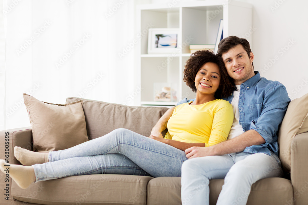 happy smiling international couple on sofa at home happy smiling international couple on sofa at home