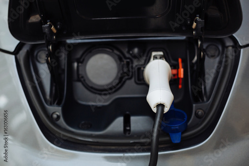 White electrical nozzle charging an e-car