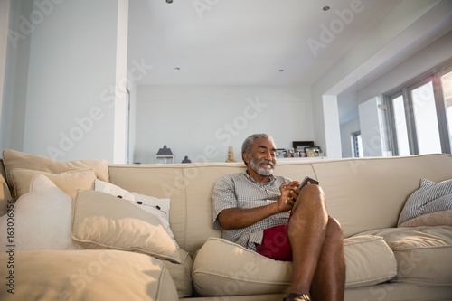Senior man using mobile phone in the living room © wavebreak3