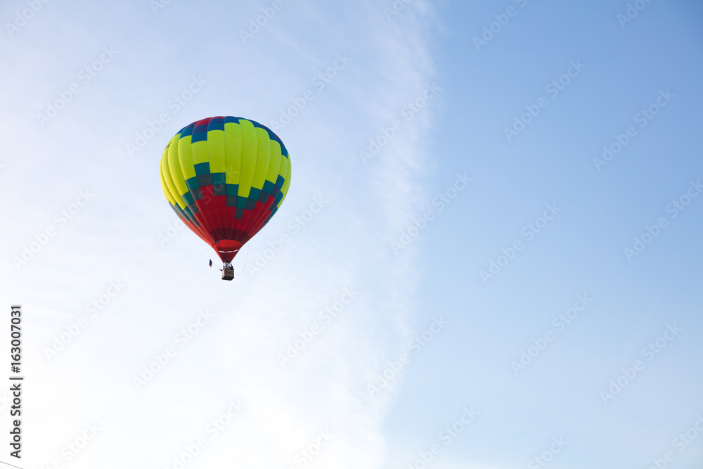 Naklejka premium Bright aerostat in cloudy blue sky