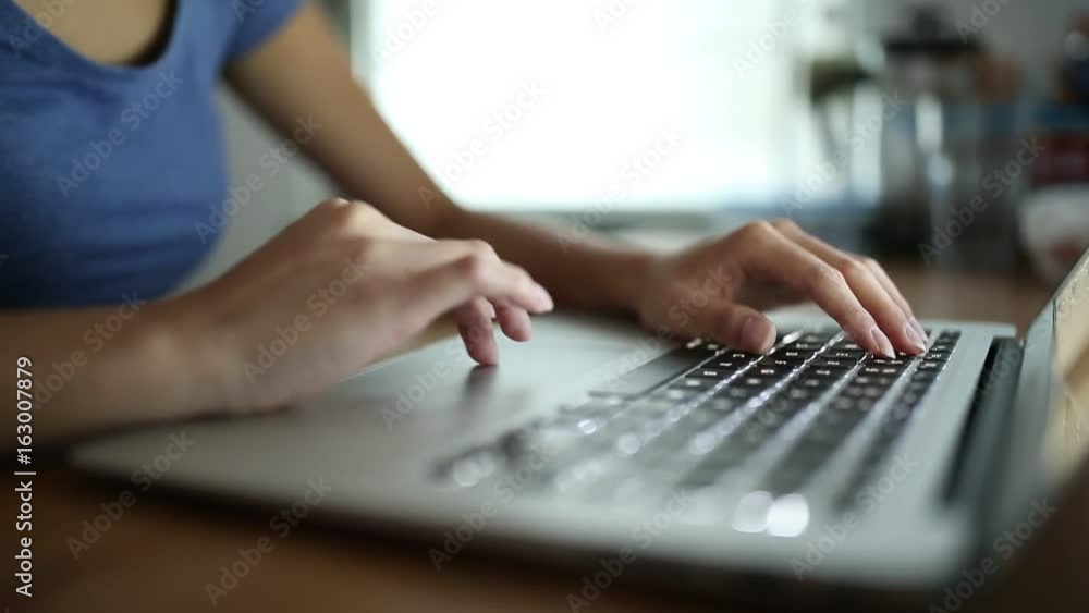Woman typing on laptop computer at home Woman typing on laptop computer at home