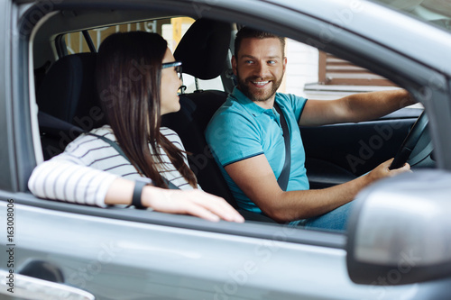 Happy couple sitting in their new car photo