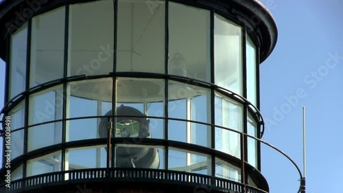 Close-up of lighthouse at Gay Head Aquinnah on Martha's Vineyard with rotating red and white lights behind glass against blue sky photo