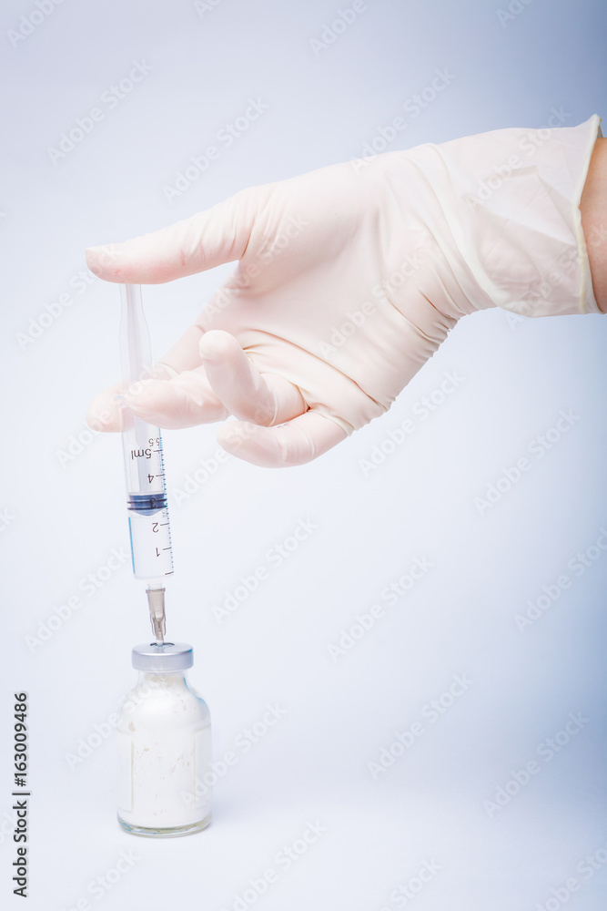 Health nurse worker dials the vaccine into a syringe Health nurse worker dials the vaccine into a syringe