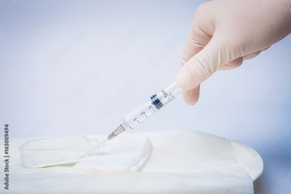 Health nurse worker dials the vaccine into a syringe Health nurse worker dials the vaccine into a syringe