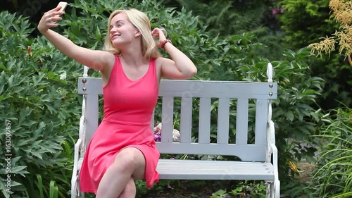 Wallpaper Mural Happy attractive woman taking a selfie in a park on a nice sunny day. Torontodigital.ca