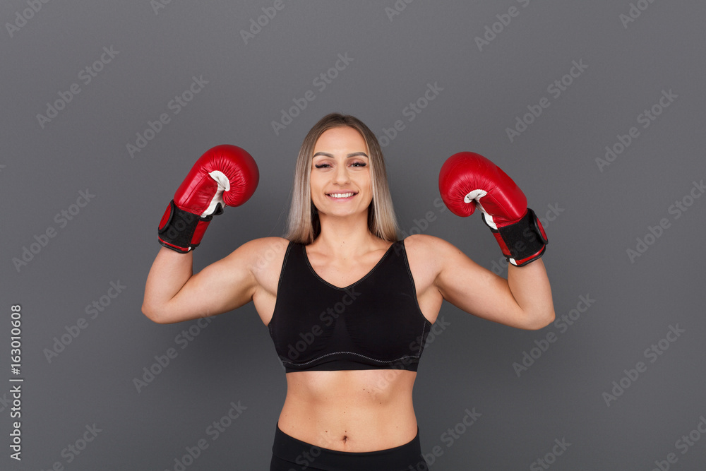 Strong female boxer showing muscles