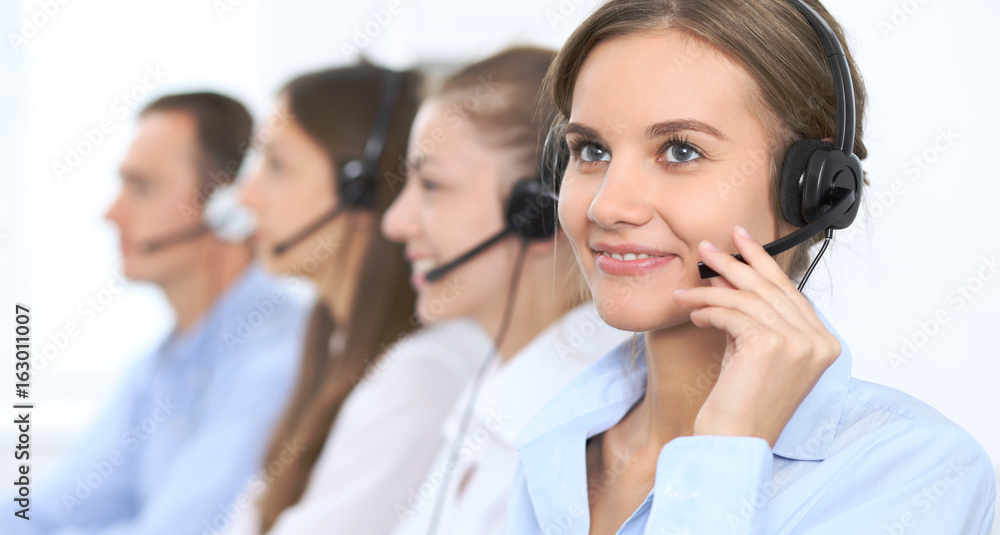 Call center operator in headset while consulting client. Telemarketing or phone sales. Customer service and business concept Call center operator in headset while consulting client. Telemarketing or phone sales. Customer service and business concept