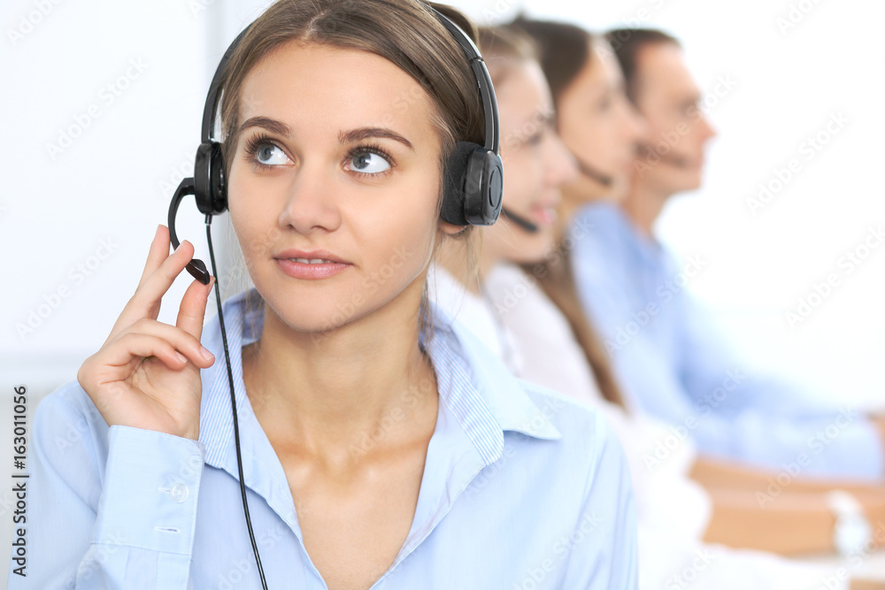 Call center operator in headset while consulting client. Telemarketing or phone sales. Customer service and business concept Call center operator in headset while consulting client. Telemarketing or phone sales. Customer service and business concept