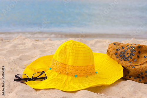 summer composition with hat  bag and sunglasses on a sand beach