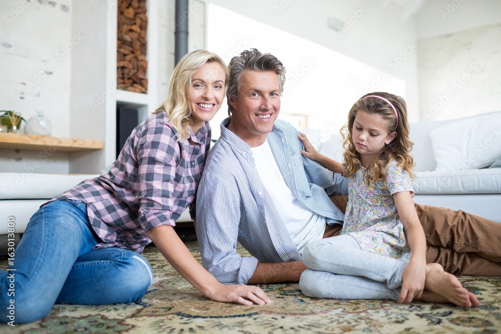Happy family sitting on floor in living room Happy family sitting on floor in living room