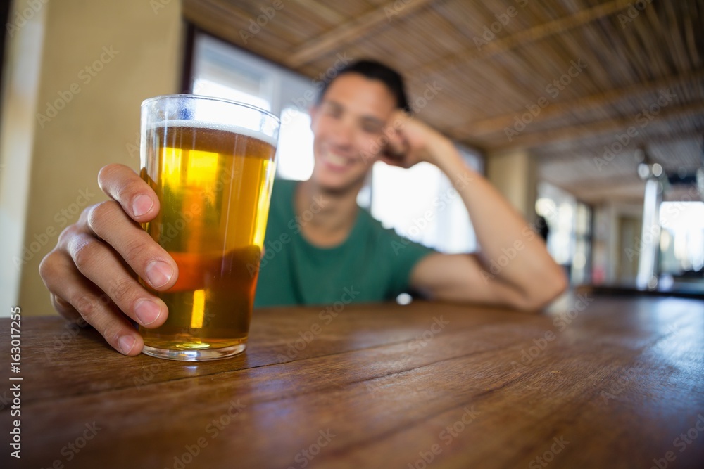 Man holding beer glass at bar counter